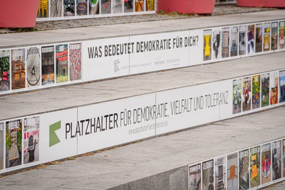 Sitzstufen, Platzhalter für Demokratie Sitzstufen beklebt mit Aufnahmen von Stühlen